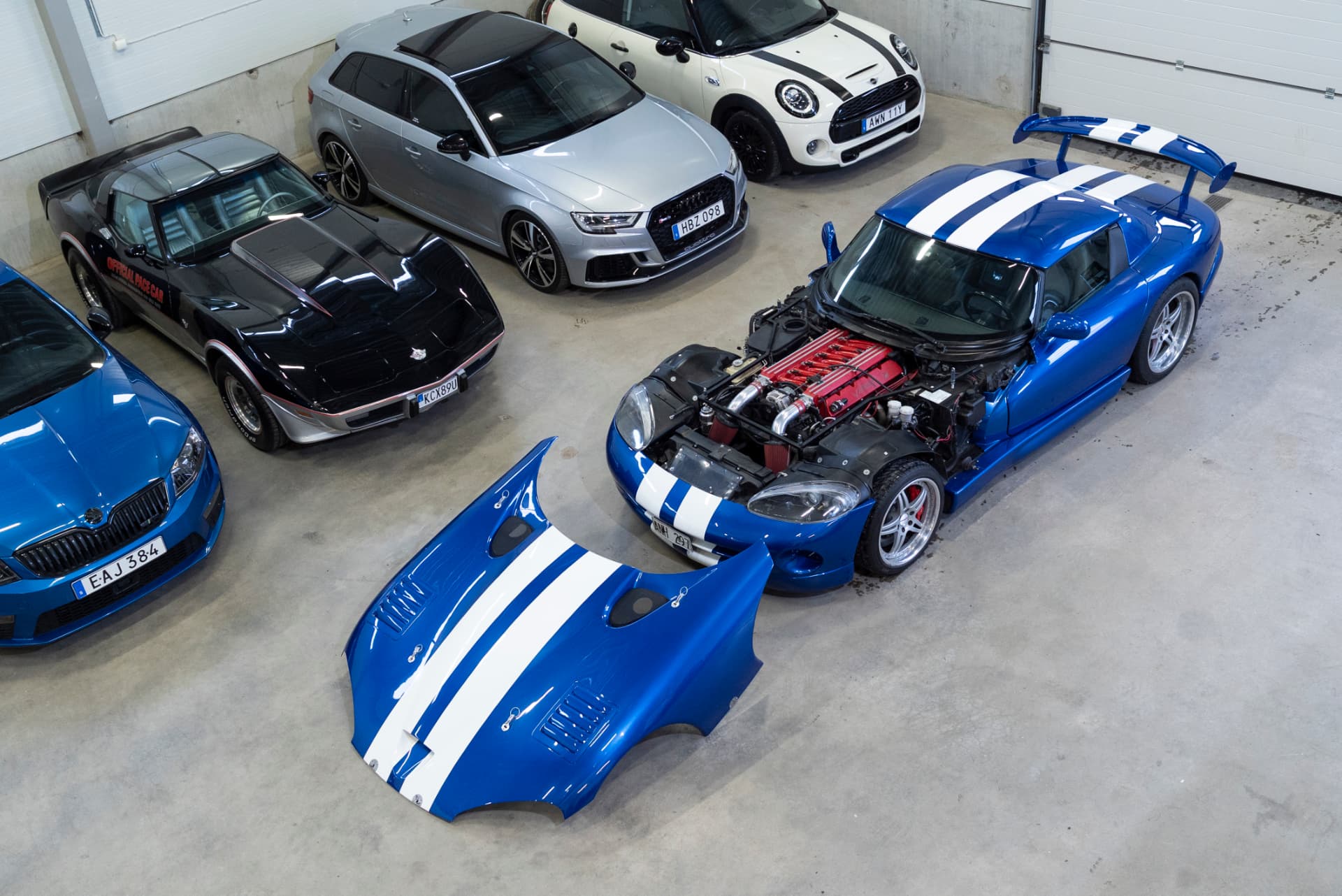 Dodge Viper RT/10 med avtagen glasfiberhuv och synlig V10-motor bland andra bilar i lokalen