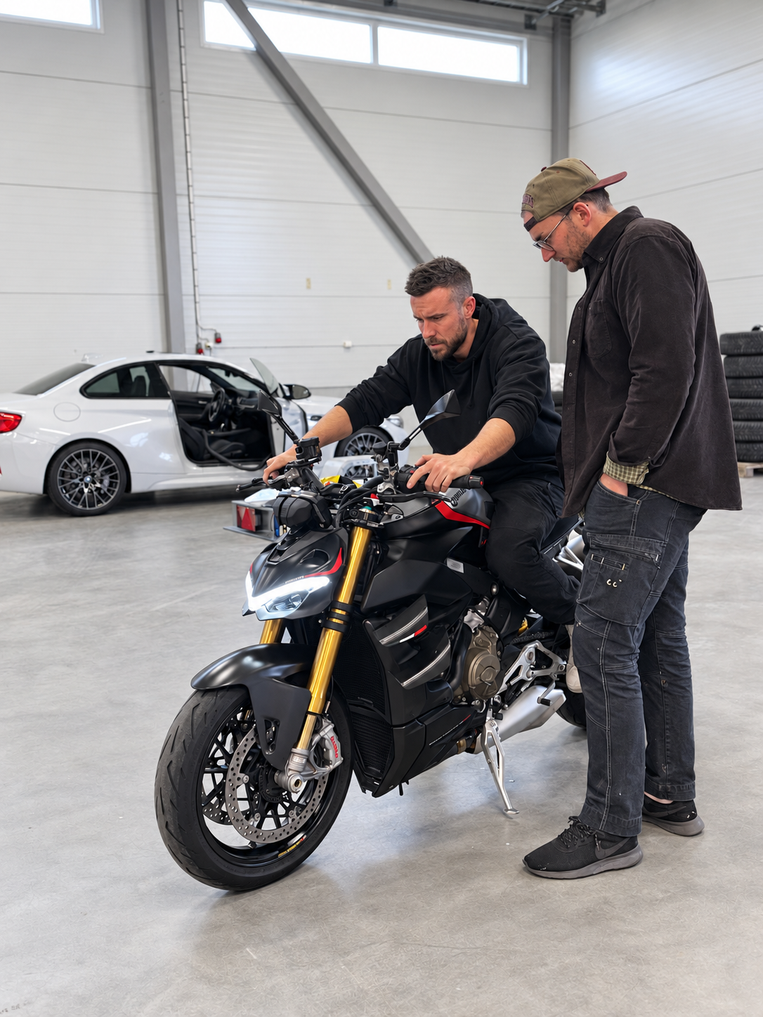 RT Motor köper motorcykel – en mattsvarthållen Ducati Streetfighter i lokalen i Köping, med en av oss sittande på hojen