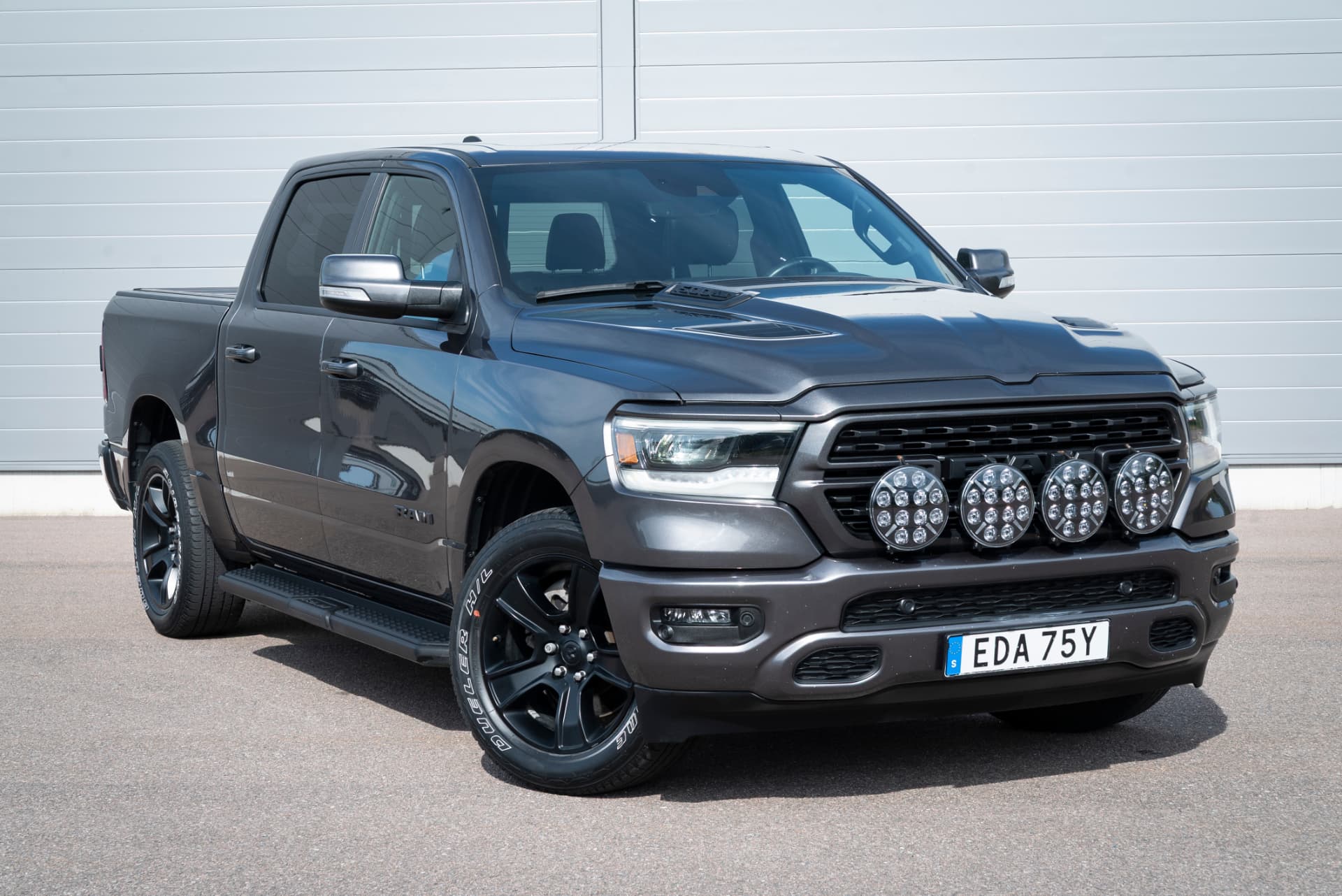Grå Ram 1500 Sport med extraljus fotograferad snett framifrån
