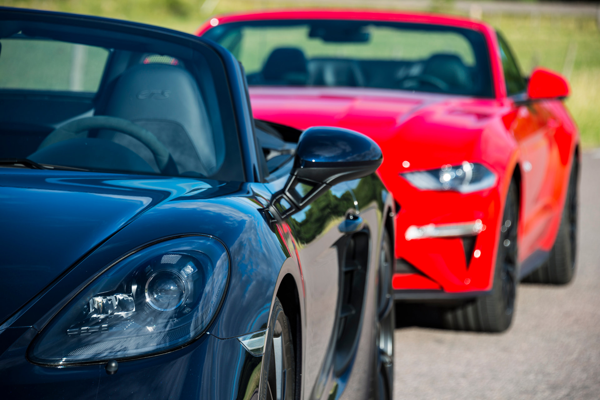 Sportbilar hos RT Motor – en mörkblå Porsche GTS och en röd cabriolet