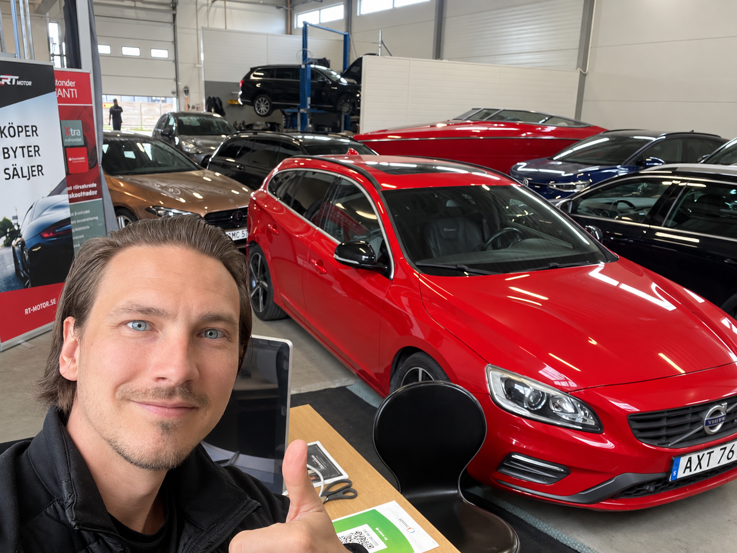 Tom Ljungqvist i RT Motors lokal tillsammans med bilar till försäljning
