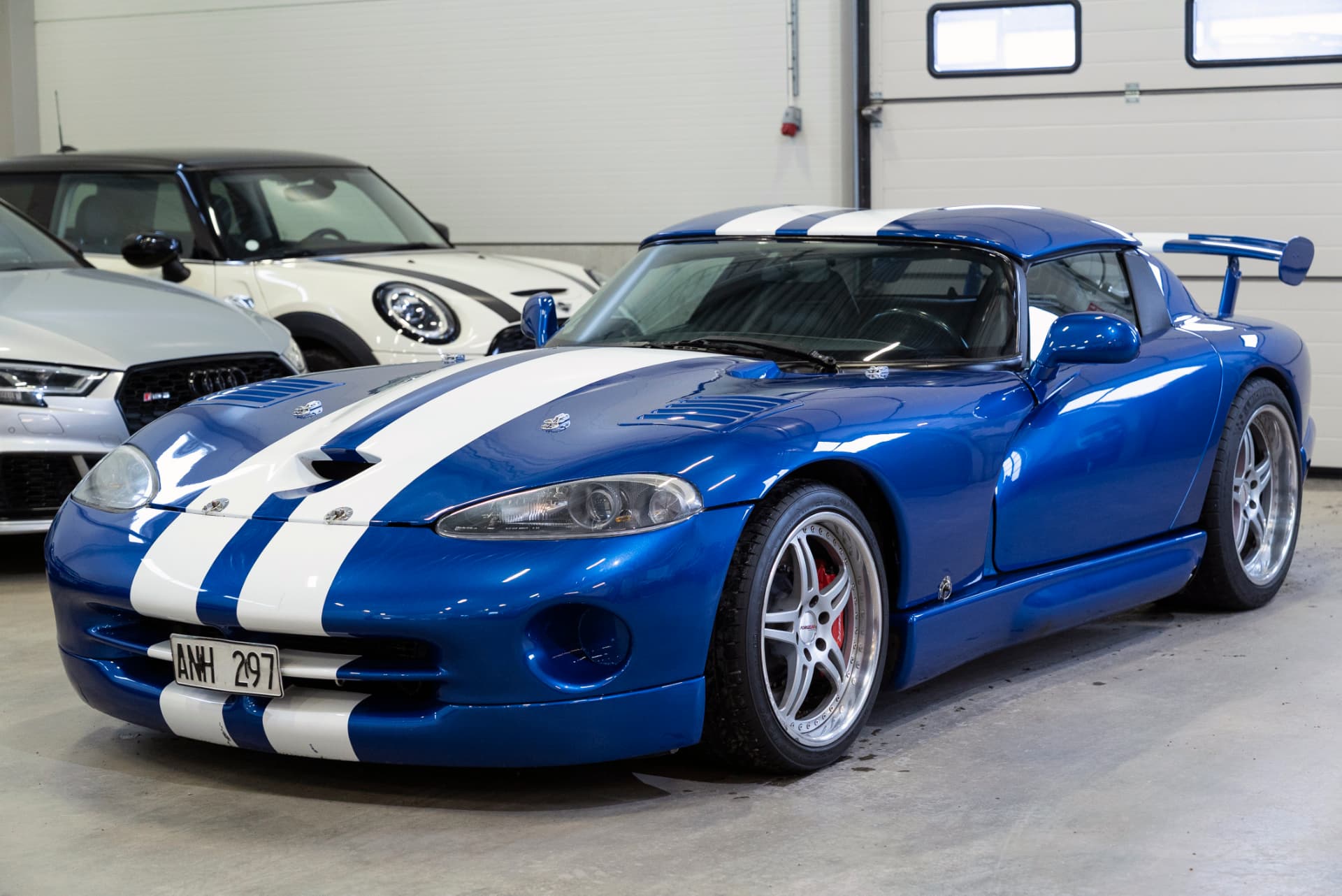 Blå Dodge Viper RT/10 1995 med vita ränder sedd framifrån i trekvartsvy i lokalen